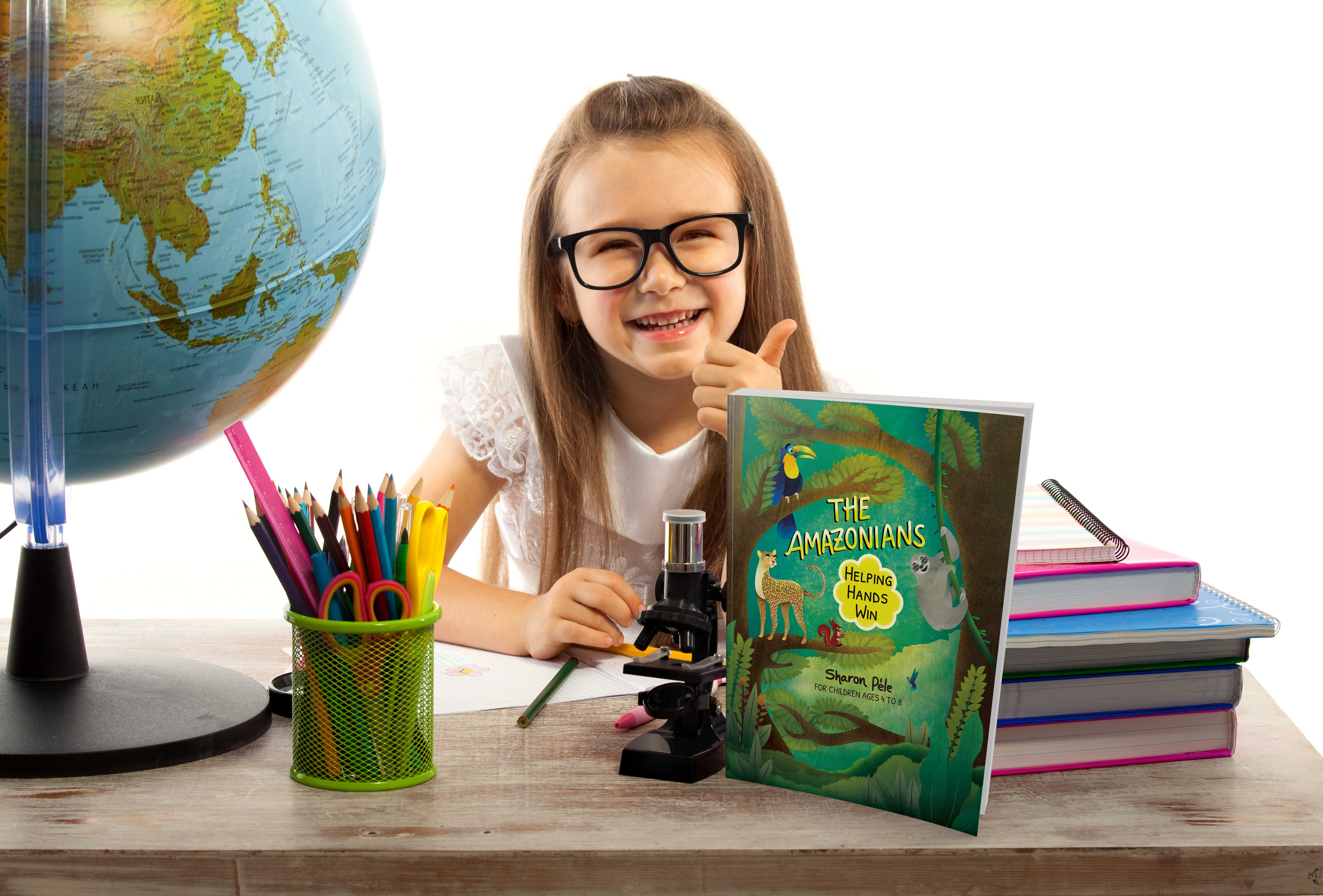 girl showing thumb up sitting with globe at desk