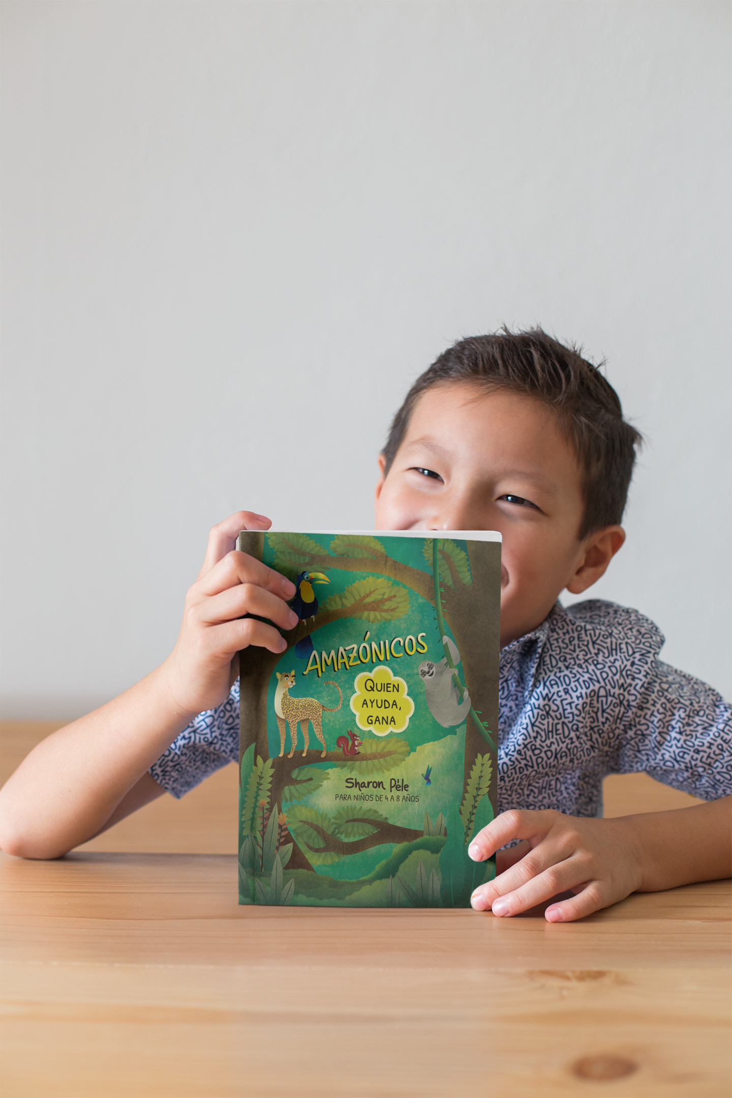 book mockup of a little boy smiling and showing off his book 23725