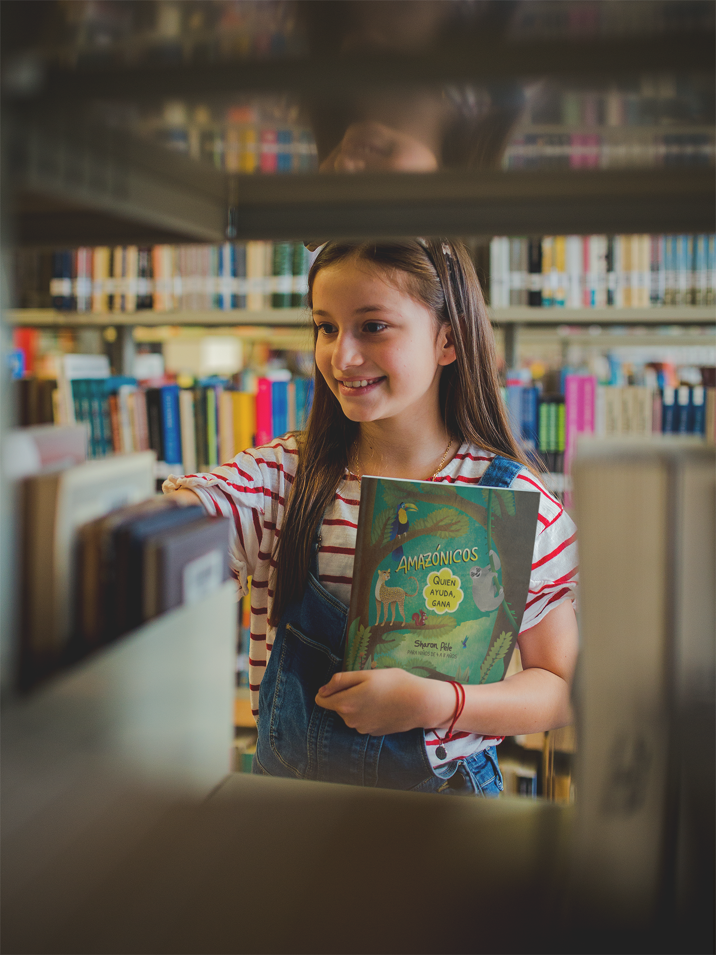 smiling girl holding a book template at a library a19275