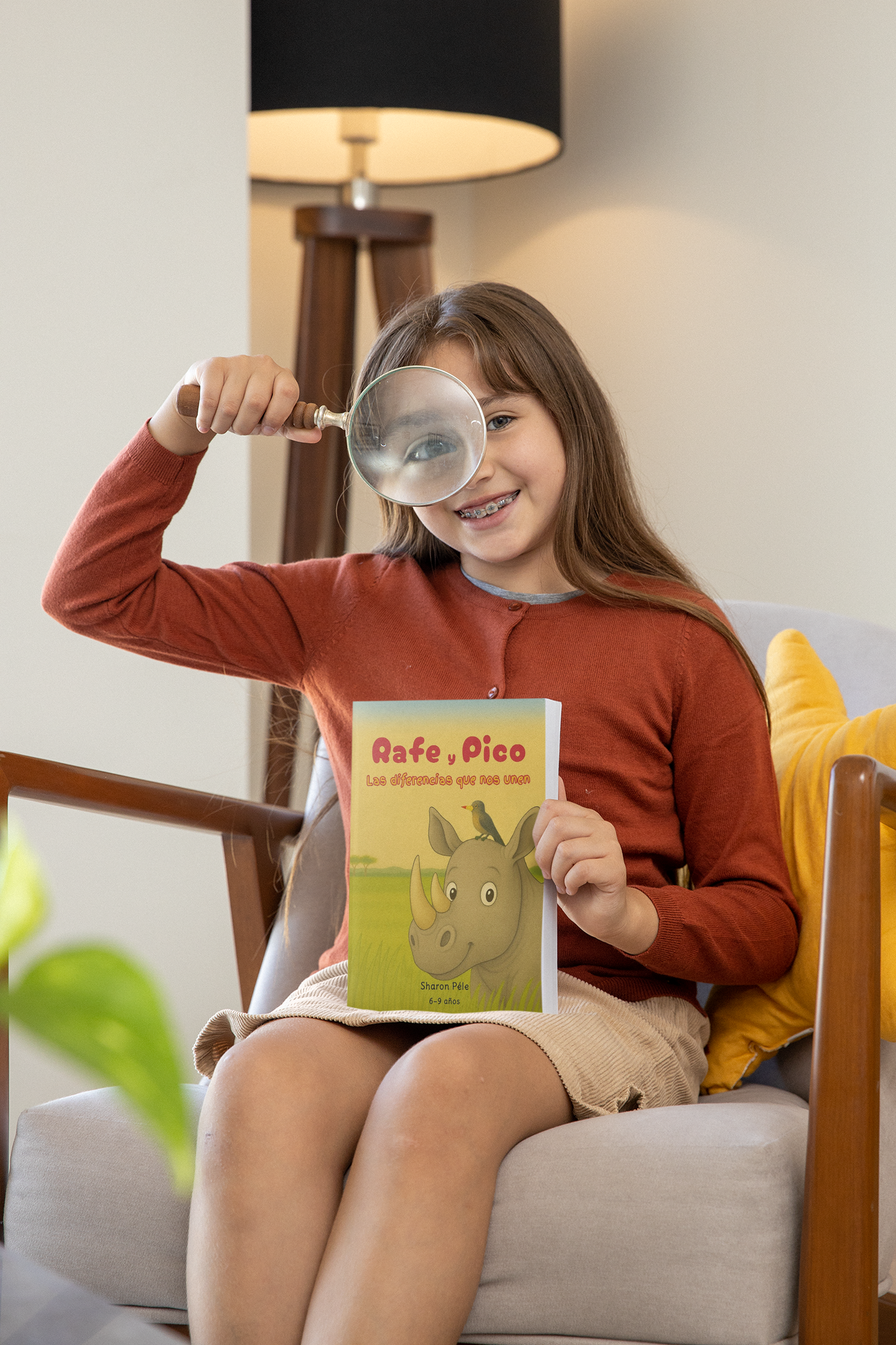 Rafe and Pico United by Our Differences book mockup of a girl playing with a magnifying glass in her living room m26924 (3)